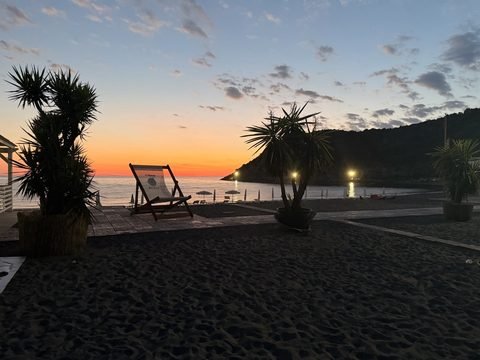 La sdraio di L'Approdo Due sulla spiaggia di Castrocucco di Maratea al tramonto, con il mare e il promontorio