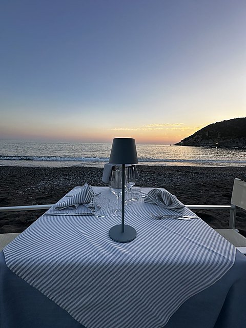 Tavolo con lampada al tramonto sulla spiaggia